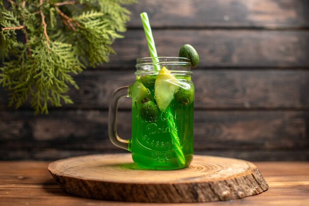 Vista frontal de jugo fresco con manzana y feijoa en una bandeja de madera