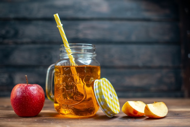 Foto gratuita vista frontal de jugo de manzana fresco dentro de lata con manzanas frescas en la barra oscura foto de bebida de frutas color cóctel
