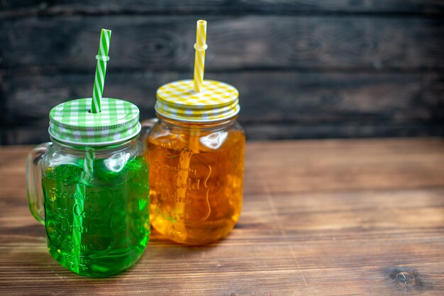 Vista frontal de jugo de manzana fresco dentro de latas en color de barra de fotos de bebida de fruta oscura