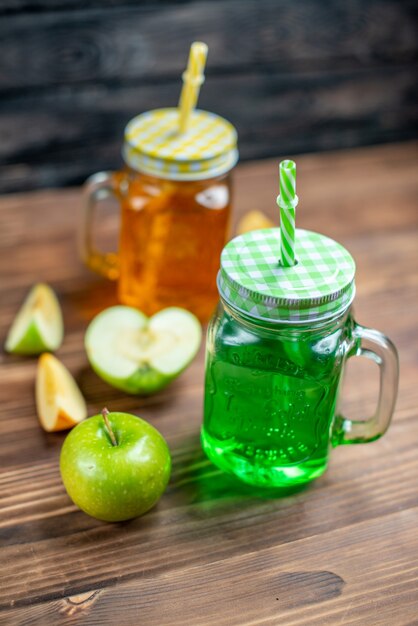 Vista frontal de jugo de manzana fresco dentro de latas en colores de barra de cócteles de bebidas de frutas oscuras