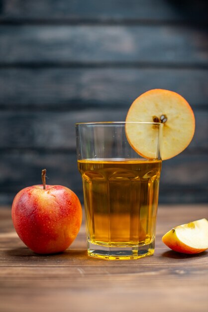 Vista frontal de jugo de manzana fresco con manzanas frescas en una bebida oscura, cóctel de frutas de color fotográfico