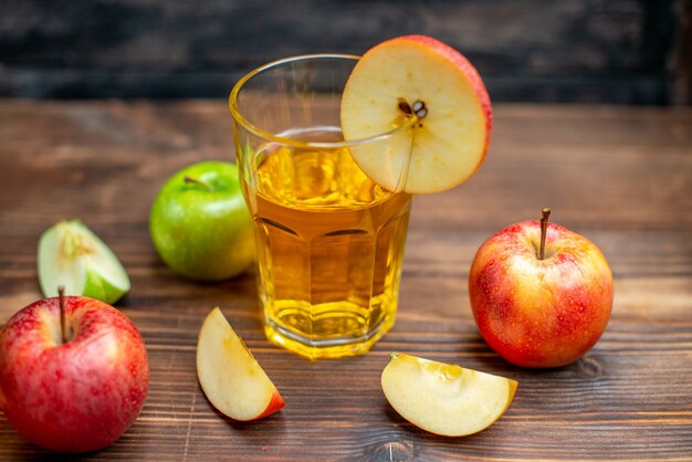 Vista frontal de jugo de manzana fresco con manzanas frescas en la foto oscura bebida de color cóctel de frutas