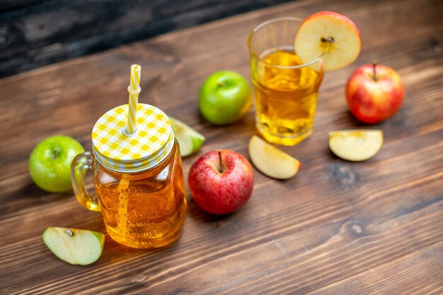 Vista frontal de jugo de manzana fresco con manzanas frescas en la foto oscura bebida de color cóctel de frutas