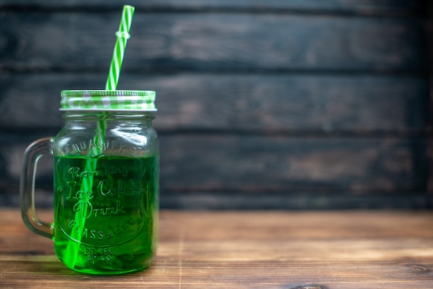 Foto gratuita vista frontal de jugo de manzana verde dentro de lata en el color marrón de la bebida de frutas de cóctel de fotos de madera
