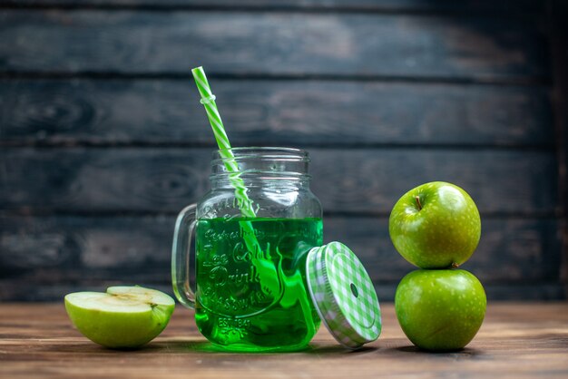 Vista frontal de jugo de manzana verde dentro de lata con manzanas frescas en color de barra de cócteles de bebida de frutas oscuras