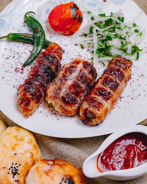 Vista frontal khan kebab con pimiento picante a la parrilla y tomate con cebolla y hierbas