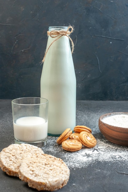 Vista frontal de leche fresca con galletas, harina y huevos en el fondo gris, pastel de color, alimentos crudos, cocina, pastel de polvo, foto