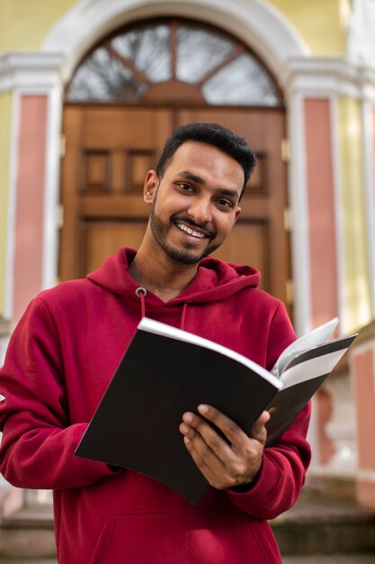 Vista frontal del libro de explotación de hombre sonriente