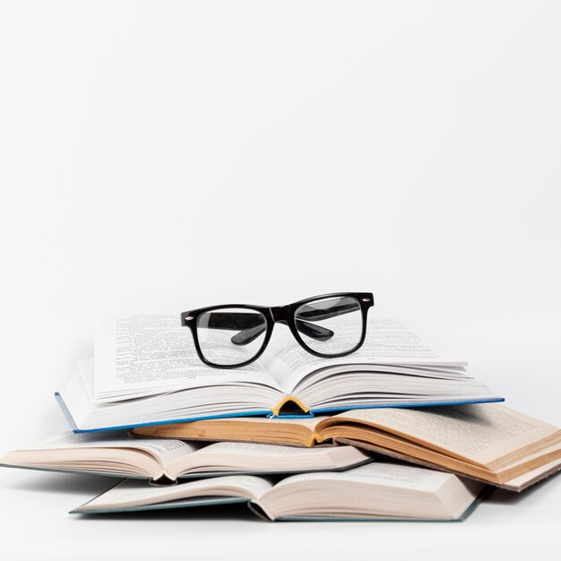 Vista frontal libros abiertos con gafas