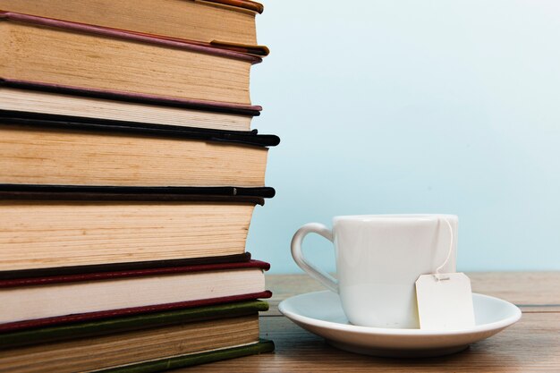 Vista frontal de libros y taza de té con espacio de copia