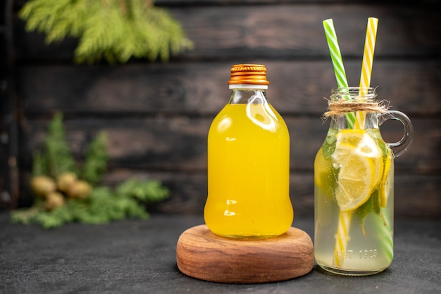 Vista frontal de limonada fresca y jugo de naranja en botellas