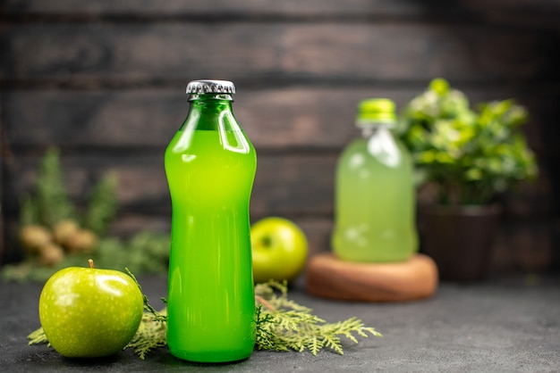 Vista frontal de limonada de manzana fresca en botella botella de jugo de planta en maceta de manzana