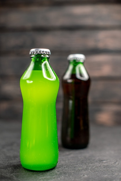 Vista frontal de limonada verde y negra en botellas