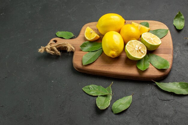 Vista frontal limones amarillos frescos frutos amargos sobre fondo oscuro