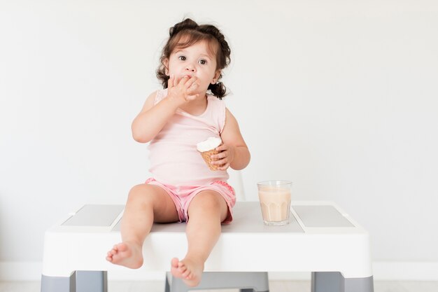 Vista frontal linda chica comiendo helado