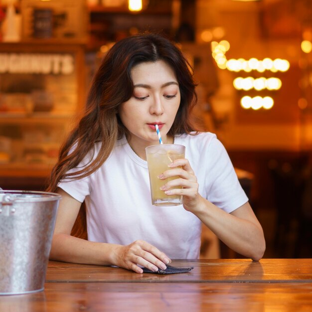Vista frontal de la linda chica japonesa bebiendo limonada