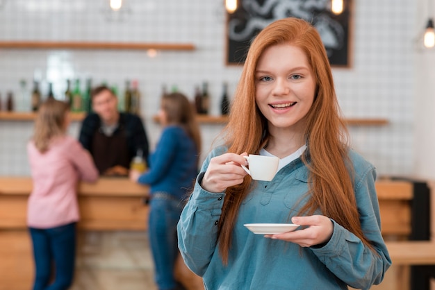 Vista frontal de linda chica tomando café