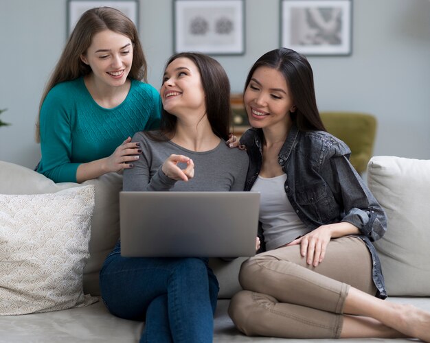 Vista frontal lindas mujeres jóvenes juntas en casa