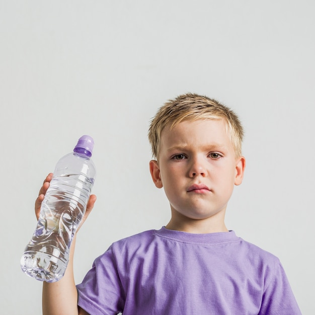 Vista frontal lindo niño con una botella de agua