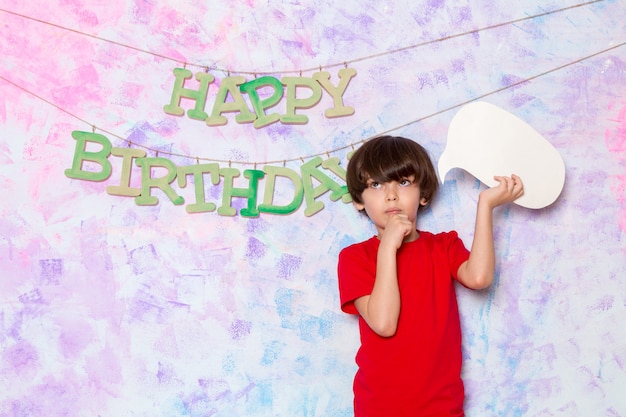 Foto gratuita una vista frontal lindo niño pequeño en camiseta roja con cartel blanco