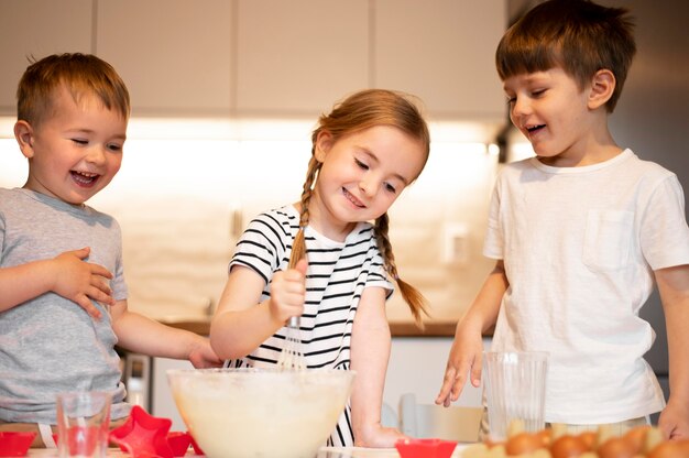 Vista frontal de lindos hermanos cocinando en casa