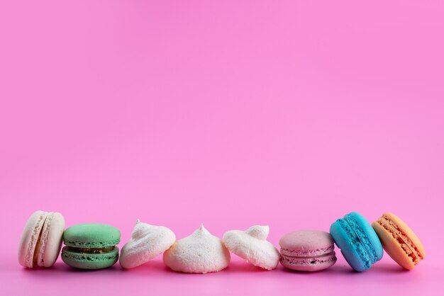 Una vista frontal macarons franceses deliciosos y coloreados en rosa, pastel de azúcar de color galleta