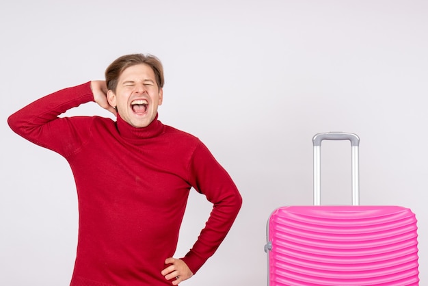 Vista frontal macho joven con bolsa rosa gritando sobre un fondo blanco emoción modelo viaje vuelo verano vacaciones de color