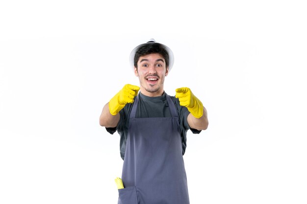 Vista frontal macho joven en guantes amarillos sobre fondo blanco flor arbusto planta trabajo jardín hierba árbol jardinero verde