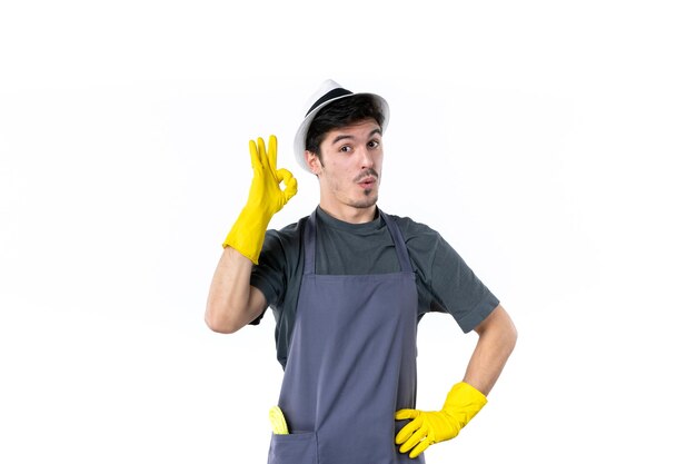 Vista frontal macho joven en guantes amarillos sobre fondo blanco flor hierba arbusto planta trabajo jardín árbol jardinero