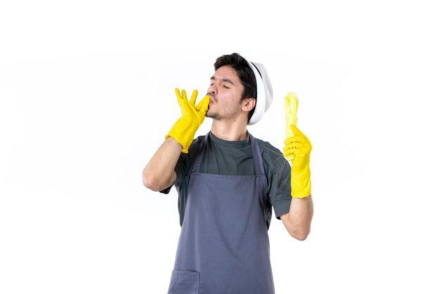 Vista frontal macho joven en guantes amarillos sosteniendo cuerdas sobre fondo blanco jardín de flores hierba jardinero trabajo verde planta de arbusto