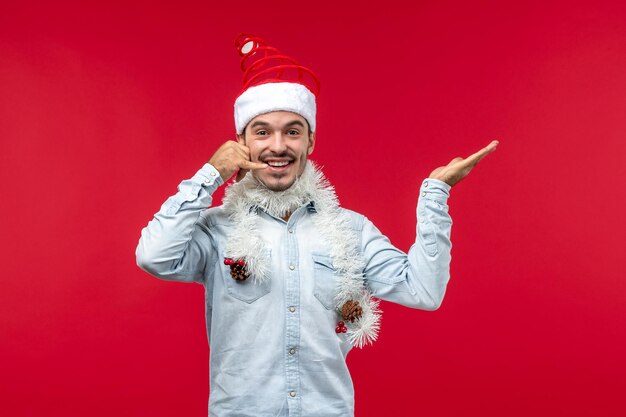 Vista frontal macho joven imitando llamada telefónica, vacaciones de navidad