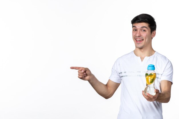 Vista frontal macho joven sosteniendo una botella de limonada en blanco