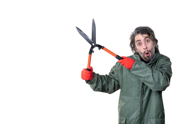 Vista frontal macho joven sosteniendo tijeras de jardín en el fondo blanco planta jardinero flor hombre trabajo suelo trabajo emoción árbol hierba