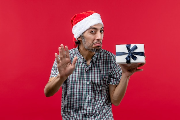 Foto gratuita vista frontal, de, macho joven, tenencia, regalo de navidad, en, rojo