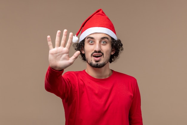 Vista frontal macho en rojo mostrando el número en el fondo marrón vacaciones emoción navidad