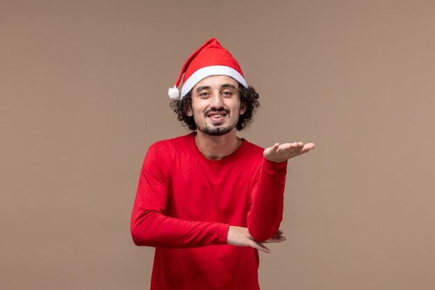 Vista frontal macho en rojo sonriendo sobre fondo marrón vacaciones emoción navidad