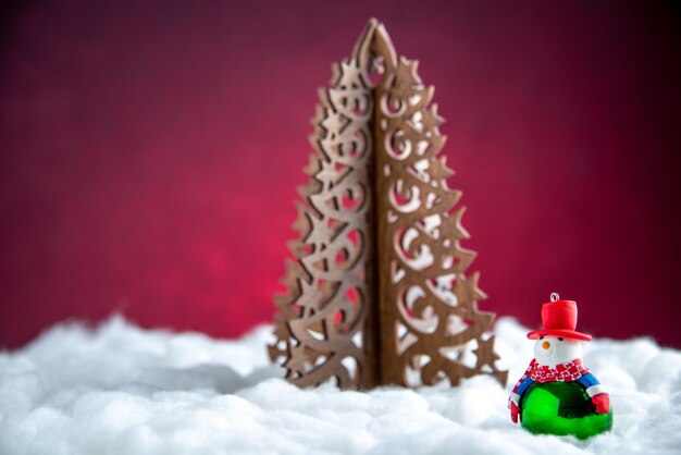 Vista frontal de madera árbol de navidad pequeño muñeco de nieve