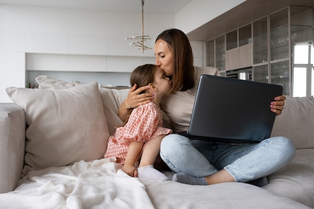 Vista frontal de la madre abrazando a la niña