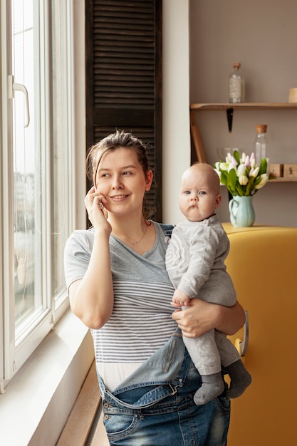 Foto gratuita vista frontal madre con bebé en casa