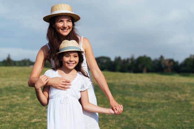 Vista frontal madre e hija al aire libre