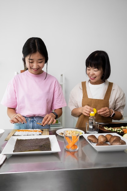 Vista frontal madre e hija cocinando