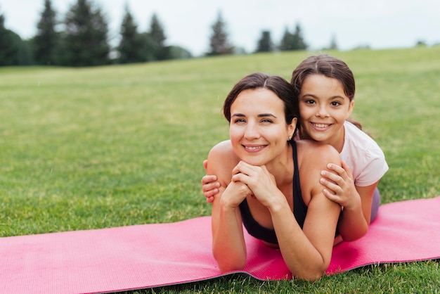 Foto gratuita vista frontal madre e hija posando en la naturaleza