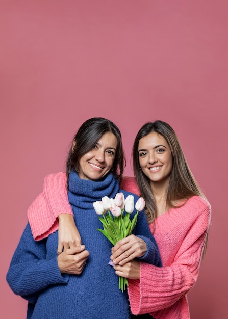 Foto gratuita vista frontal madre con flores de hija