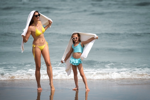 Vista frontal madre y niña en la playa