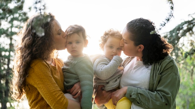 Vista frontal de madres lgbt al aire libre en el parque con sus hijos