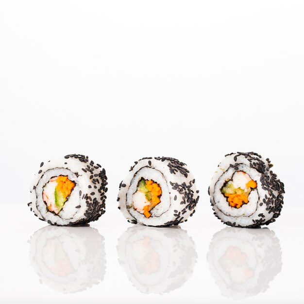 Vista frontal maki sushi rolls con semillas de sésamo