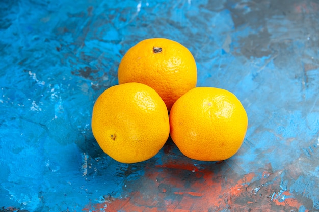 Vista frontal mandarinas frescas sobre la mesa azul