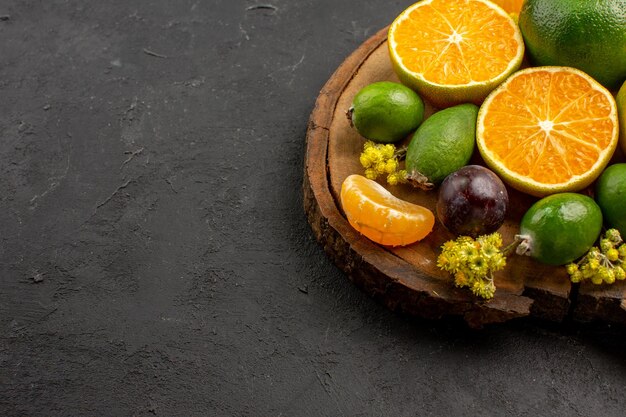 Vista frontal mandarinas verdes frescas con feijoas en el escritorio oscuro frutas exóticas verde cítrico agrio fresco