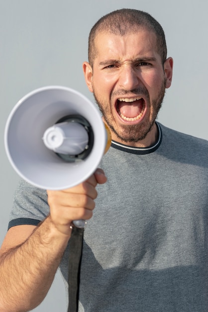 Vista frontal manifestante con megáfono gritando