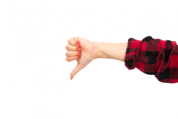 Una vista frontal mano femenina en camisa a cuadros negro-rojo que muestra signo no genial en el blanco